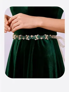 Vue détaillée d'une ceinture de mariée en strass vintage sur une robe verte.