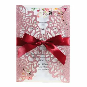 Pink glitter laser-cut wedding invitation card with red ribbon and elegant floral insert