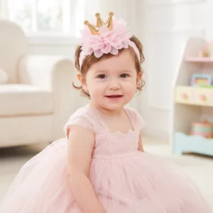 Sweet pink flower lace headband with golden crown worn by a toddler girl in a dress.