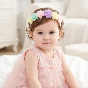 Close-up of a sweet baby girl wearing a multi-colored floral chiffon headband with pearls