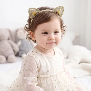 Close-up detail of a sweet golden lace cat ear headband worn by a cute baby girl