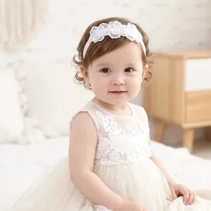 Detailed view of a sweet white floral lace elastic headband worn by a toddler girl