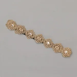 Close-up view of a golden floral lace headband decorated with sparkling rhinestones