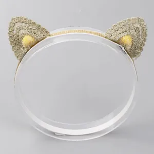 Close-up detail of a sweet golden lace cat ear headband for kids on a clear stand