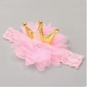 Close-up detail of the pink chiffon flower and gold crown on a lace baby headband
