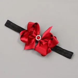 Close-up of elegant red satin bow headband with sparkling rhinestone center detail