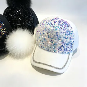 Detailaufnahme von funkelnden Pailletten und Strassbesatz an einer weißen Baseballkappe