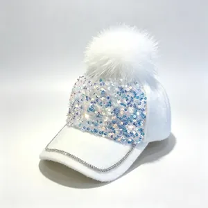 Detailansicht einer weißen Pailletten-Baseballkappe mit Pelzbommel und Strass