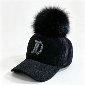 Detail van zwarte nertsfluwelen honkbalpet met bontpompom en strass letter D