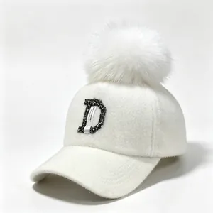 Detailopname van witte nertswollen honkbalpet met strass letter D en een zachte pompon