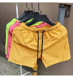 Detail of candy-colored quick-dry beach shorts with elastic drawstring waist.