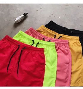 Macro view of colorful quick-dry beach shorts in red, green, pink, and yellow.