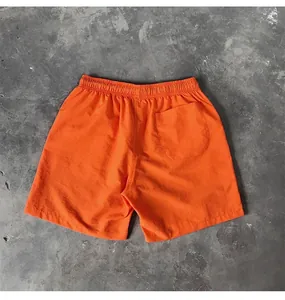 Back view of bright orange quick-dry beach shorts with a single rear pocket.
