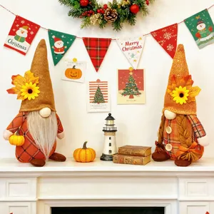 Pair of cozy autumn harvest gnomes with sunflowers and maple leaves decor on white mantel.