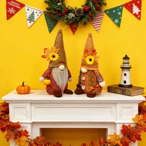 Detailed view of two autumn harvest gnomes with sunflowers and pumpkins on a white mantle