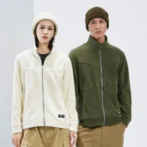 Close-up detail of couple wearing warm polar fleece full zip jackets in off-white and olive green