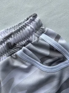 Detailed macro shot of the breathable mesh fabric on grey camouflage sports shorts