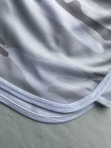 Close-up of breathable mesh fabric on grey camouflage running shorts with white binding