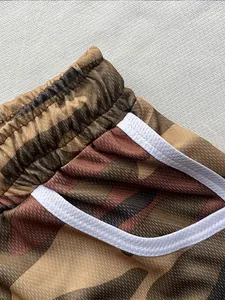 Close-up of breathable camouflage mesh shorts with elastic waistband and white trim