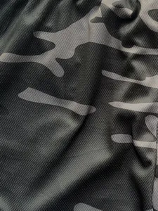 Detailed macro view showing breathable mesh fabric texture of camouflage sports shorts