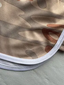 Macro detail of breathable mesh fabric on camouflage running shorts with white trim