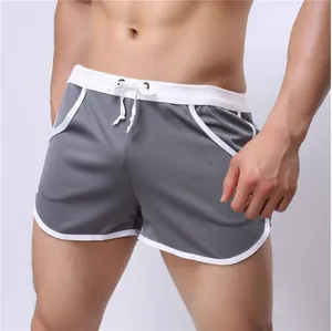 Close-up of grey breathable mesh sports shorts with white trim on a fit male model