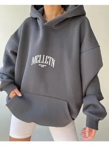 Macro view of a dark grey oversized hoodie featuring a white letter print design