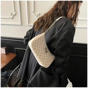 Detail of fashion monogram crescent underarm bag with gold chain strap