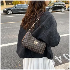 Close-up detail of a stylish crescent hobo bag with M monogram print in a street style setting.