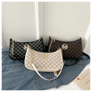 Detailed view of three crescent underarm bags with M-letter print in various colors