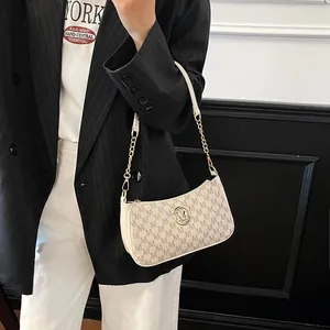 Stylish cream underarm bag featuring M monogram print and elegant gold chain strap