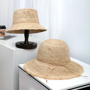 Handwoven fine raffia straw hats in bucket and wide-brim styles with natural bow detail