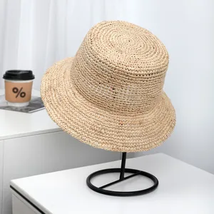 Detailed texture of high-quality handcrafted raffia straw bucket hat on display stand