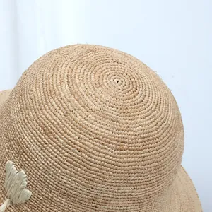 Close-up of high-quality fine raffia straw weaving texture on a wide-brim sun hat