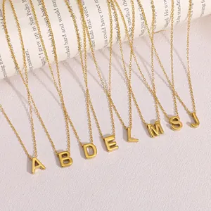 Vista detallada de varios collares de acero inoxidable dorado con letras iniciales