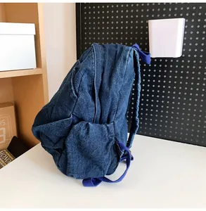 Primer plano que muestra la textura de la mochila pequeña de mezclilla lavada.