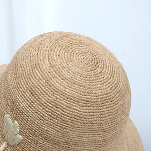 Close-up of high-quality hand-woven raffia straw sun hat texture and crown detail