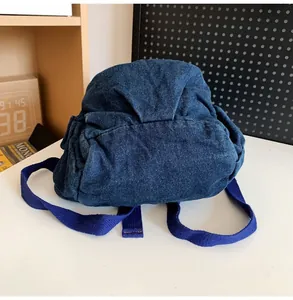 Vista posterior detallada de la pequeña mochila vintage en tela vaquera azul