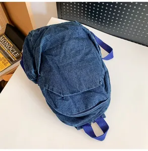 Vista superior de mini mochila de mezclilla azul desgastado sobre fondo blanco