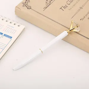 Bolígrafo de metal blanco elegante con un gran diamante de cristal arriba.