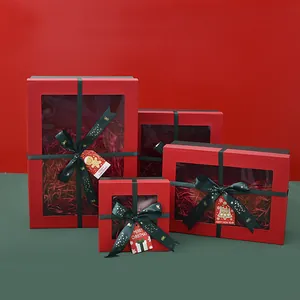 Detalle de cajas de regalo rojas de Navidad con ventana y cintas de raso verde