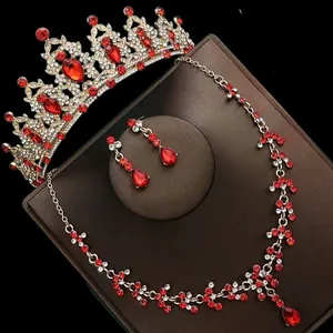Luxurious bridal jewelry set with red stones, crown necklace and earrings detail. Perfect style.