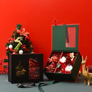 Vista detallada de la caja de regalo de Navidad abierta con rosas rojas y manzanas.