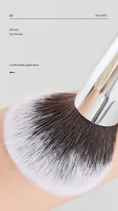 Detailweergave van zachte witte en bruine make-up penseelharen op de huidoppervlak.
