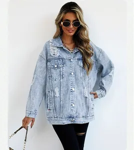 Close-up detail of oversized light wash denim jacket featuring vintage distressed accents