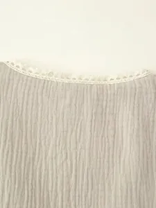 Detailed close-up of a vintage vest neckline with white lace trim and gauze fabric texture.