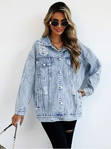 Close-up view of oversized light blue distressed denim jacket with ripped accents and buttons