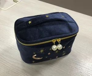 Detailansicht einer dunkelblauen Samt-Kosmetiktasche mit Sternenstickerei und Perlen-Zippern.