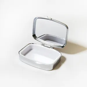 Petite boîte à pilules en métal argenté avec miroir intérieur et compartiment blanc