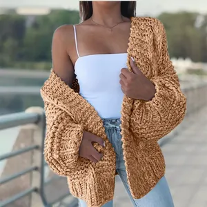 Close-up of chunky knit camel cardigan with textured cable pattern and loose fit